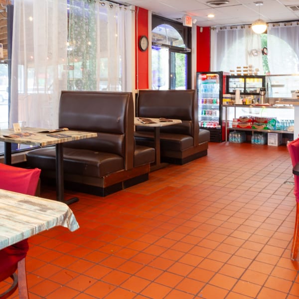 Interior of Indian 5 Stars Restaurant with brown booths, orange tiled floor, and a dessert counter.